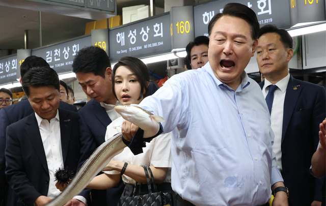 윤석열 대통령이 27일 부산 중구 자갈치시장에서 장어를 직접 손으로 잡아 보며 즐거워 하고 있다. 부산=연합뉴스