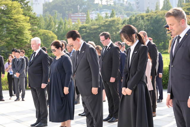 윤석열 대통령과 김건희 여사가 27일 부산 남구 유엔기념공원을 찾아 22개 참전국 정부대표들과 함께 유엔군 위령탑에 헌화한 뒤 묵념하고 있다. / 연합뉴스