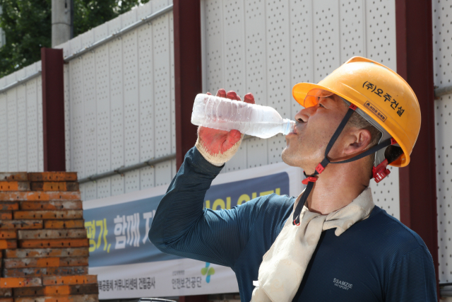 일주일째 폭염 특보가 발효된 31일 오전 광주 북구 오치동 한 공사 현장에서 한 작업자가 북구에서 제공한 생수를 마시고 있다. 연합뉴스