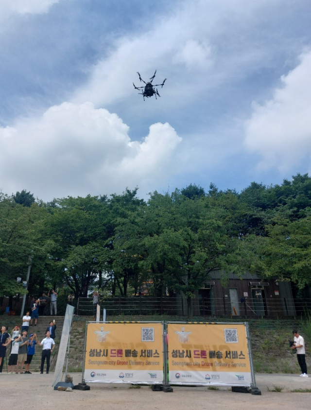 1일 오전 성남시 탄천 구미동 어린이 물놀이장에 마련된 월풀에 드론이 배달상자를 투하하고 있다. 사진 = 손대선 기자