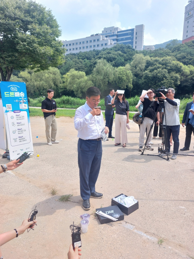 신상진 성남시장이 1일 오전 성남시 탄천 구미동 어린이 물놀이장에서 드론이 배달한 커피를 즉석에서 마시고 있다. 사진 = 손대선 기자