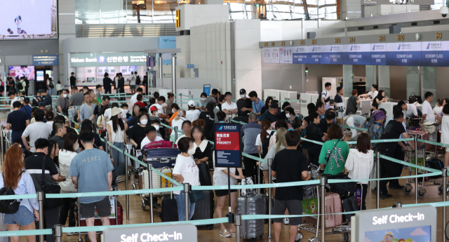 여름 휴가철인 지난달 28일 오전 인천국제공항 제1터미에서 이용객들이 줄을 서고 있다. 연합뉴스