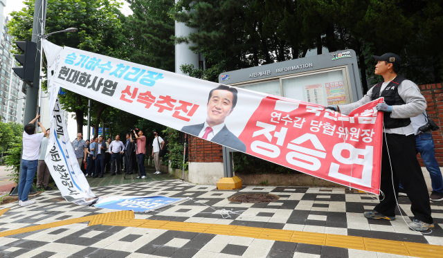 12일 오전 인천시 연수구 소금밭사거리에서 연수구청 관계자들이 시 조례위반 정당현수막을 강제 철거하고 있다. 연합뉴스