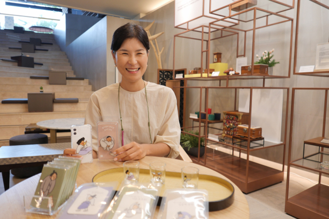 진나라 한국문화재재단 상품기획팀장이 ‘모두의 풍속도’ 시리즈로 출시된 상품들을 들어 보이고 있다.
