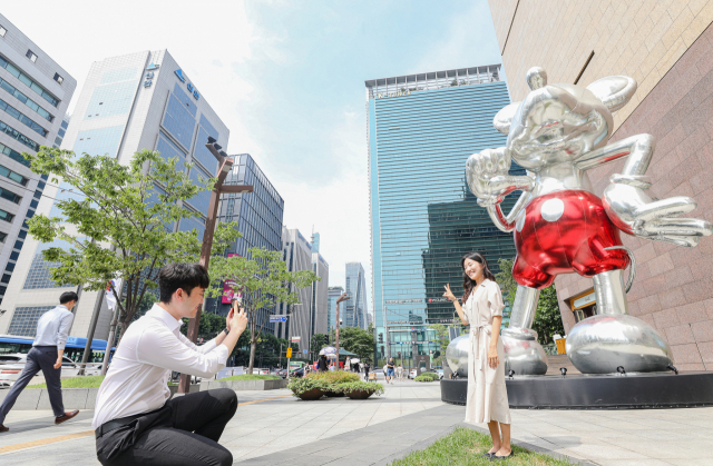 2일 서울 강남구 현대백화점 무역센터점을 방문한 고객이 1층 정문에 세워진 대형 디즈니 캐릭터 조형물 앞에서 기념 촬영을 하고 있다./현대백화점