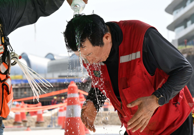 며칠째 전국에서 푹푹찌는 폭염이 이어지고 있는 2일 인천국제공항 제2합동청사 확장공사 현장에서 작업자가 머리에 물을 뿌리며 더위를 식히고 있다. 영종도=권욱 기자 2023.08.02