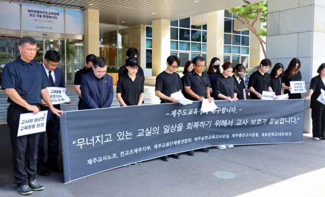 2일 제주도교육청 앞에서 열린 교육활동 보호 대책을 촉구하는 제주지역 교육단체 기자회견 참가자들이 기자회견문 발표 전 서이초 교사를 추모하며 묵념하고 있다. 연합뉴스