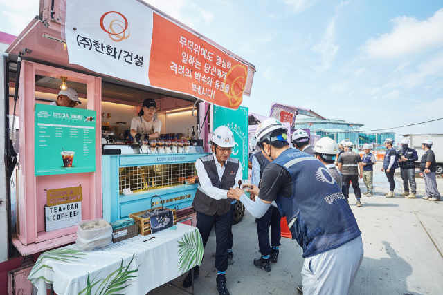 지난 3일 인천공항 제2터미널 확장공사 현장을 찾은 김승모 ㈜한화 건설부문 대표이사가 ‘찾아가는 팥빙수 간식차’ 행사에 참여해 현장 근로자들에게 팥빙수를 나눠주고 있다. 사진제공=㈜한화 건설부문