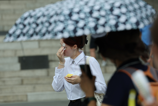 폭염에 유분 폭발 (서울=연합뉴스) 임화영 기자 = 절기상 입추(立秋)가 하루 앞으로 다가왔지만 여전히 폭염이 이어지고 있는 7일 오전 서울 남산을 찾은 관광객이 기름종이로 유분을 닦고 있다. 2023.8.7 hwayoung7@yna.co.kr (끝)