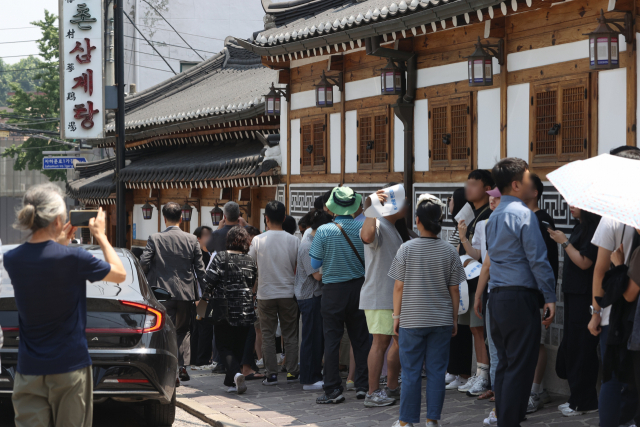 지난 21일 중복을 맞아 서울의 한 삼계탕집 앞에서 시민과 외국인들이 식사를 위해 줄을 서 있다. 사진=연합뉴스