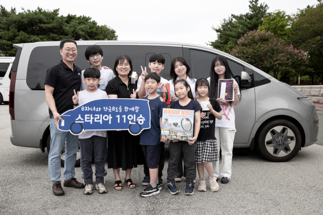 정기환(뒷줄 왼쪽) 기술기사와 가족들이 9일 현대차 전주공장에서 진행된 '저출산/육아지원 노사 TFT 간담회' 이후 증정 받은 스타리아와 기념촬영을 하고 있다. 사진 제공=현대차