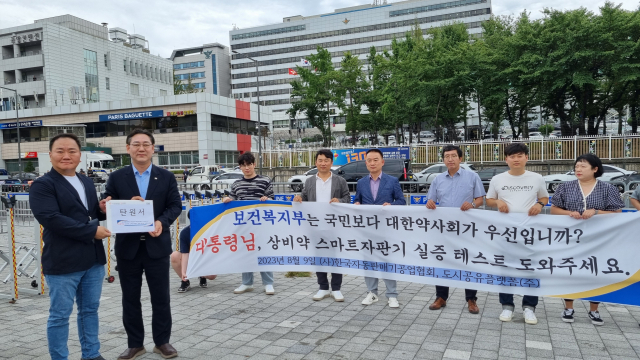 박진석 도시공유플랫폼(주) 대표(왼쪽)가 9일 오후 서울 용산구 대통령 집무실 인근 전쟁기념관 앞에서 ‘안전상비의약품 스마트자판기’의 규제 실증 테스트의 진행을 요청하는 탄원서를 김대남 대통령실 시민사회수석실 국민통합국장에게 전달하고 있다. 사진 제공=도시공유플랫폼