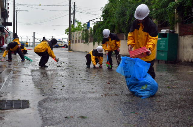 태풍 ‘카눈’의 영향으로 많은 비가 내린 뒤 그친 10일 오후 속초시 공무원이 물이 빠진 도로에서 복구작업을 하고 있다. 사진제공=속초시
