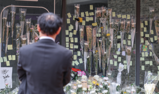 지난달 24일 서울 관악구 신림역 인근 상가 골목에서 흉기 난동으로 숨진 20대 남성 A 씨를 추모하는 공간에 추모객들이 남긴 메모와 꽃들이 놓여 있다. 연합뉴스