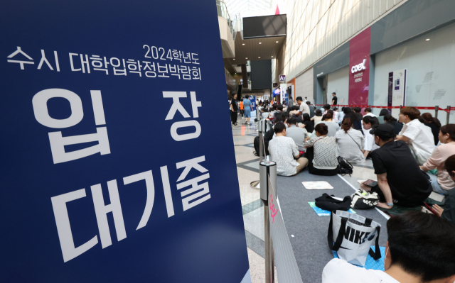 지난달 20일 서울 강남구 코엑스에서 열린 '2024학년도 수시 대학 입학 정보박람회'에서 학부모와 수험생들이 줄을 서고 있다. 연합뉴스