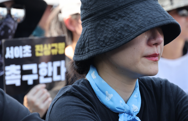 지난 5일 서울 광화문에서 열린 교사와 학생을 위한 교육권 확보를 위한 집회에서 한 교사가 사망한 서이초 교사 유가족의 발언을 들으며 눈물을 흘리고 있다.연합뉴스