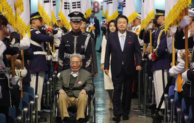 윤석열 대통령이 15일 서울 서대문구 이화여대 대강당에서 열린 78주년 광복절 경축식에서 오성규·김영관 애국지사와 함께 입국하고 있다. / 연합뉴스