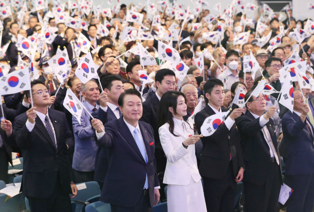 윤석열 대통령 부부가 15일 서울 서대문구 이화여대 대강당에서 열린 78주년 광복절 경축식에서 만세 삼창을 한 뒤 태극기를 ㅎ느들고 있다. / 연합뉴스