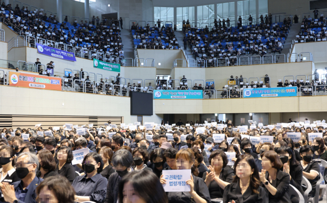 이주호 교육부총리가 17일 오후 충북 청주시 청원구 내덕동 청주대학교에서 열린 제62회 한국초등교장협의회 하계연수회에서 발언하고 있는 가운데 참석자들이 피켓을 들어 보이며 구호를 외치고 있다. 연합뉴스