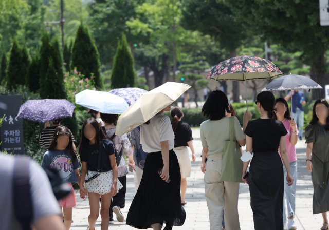 무더위가 계속된 3일 서울 종로구 삼청동길에서 시민들이 강한 햇살에 양산을 쓰고 이동하고 있다. 연합뉴스