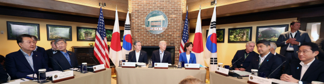 윤석열 대통령과 조 바이든(가운데 테이블 가운데) 미국 대통령, 기시다 후미오(오른쪽) 일본 총리가 18일(현지 시간) 미국 메릴랜드주의 캠프데이비드에서 한미일정상회의를 하고 있다. 캠프데이비드=연합뉴스