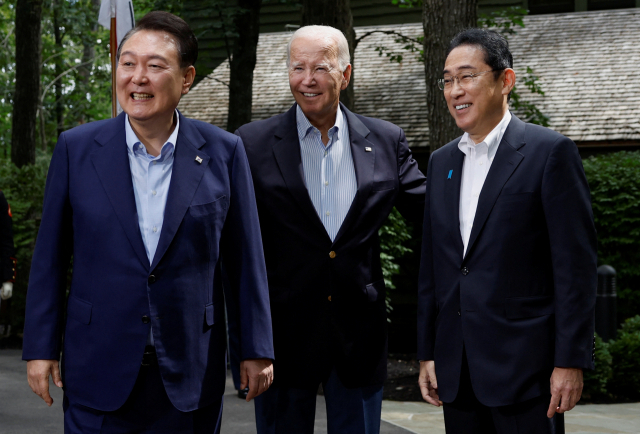 (왼쪽부터) 윤석열 대통령·조 바이든 미국 대통령·기시다 후미오 일본 총리가 18일(현지시간) 한미일 정상회의가 열린 미국 대통령 별장 캠프 데이비드에서 포즈를 취하고 있다. 세 정상은 이날 정상회의 후 공동기자회견에서 