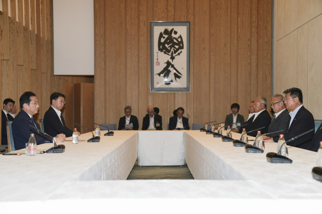기시다 후미오(왼쪽) 일본 총리가 21일 일본 도쿄에서 어업인들을 만나고 있다. AP연합뉴스