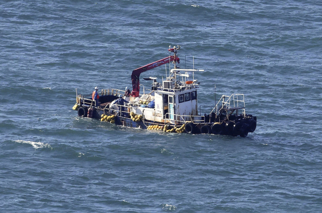 24일 일본 후쿠시마 제1원자력발전소 인근 해역에서 관측선이 해수의 방사성 물질을 검사하기 위해 샘플을 채취하고 있다. 일본은 이날 후쿠시마 오염수 방류를 개시했다.연합뉴스