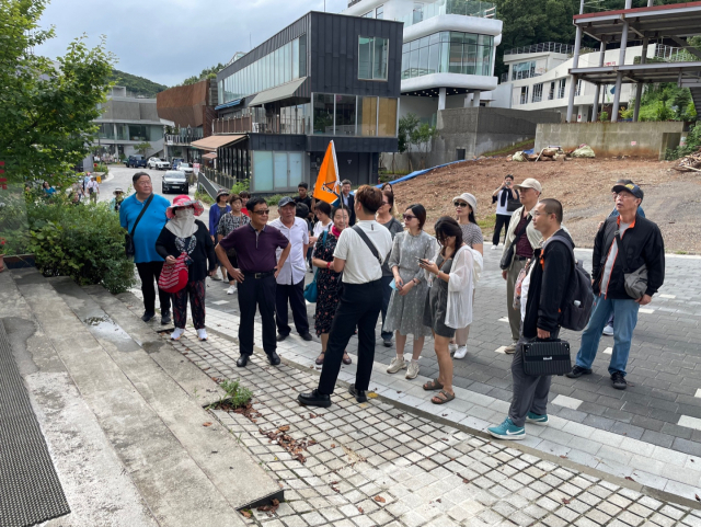 지난 24일 오후 경기 파주시 탄현면 헤이리 예술마을을 찾은 중국인 관광객 31명이 주황색 깃발을 든 여행사 직원을 따라 아트센터 '화이트블럭' 등을 관람하고 있다. 파주=연합뉴스