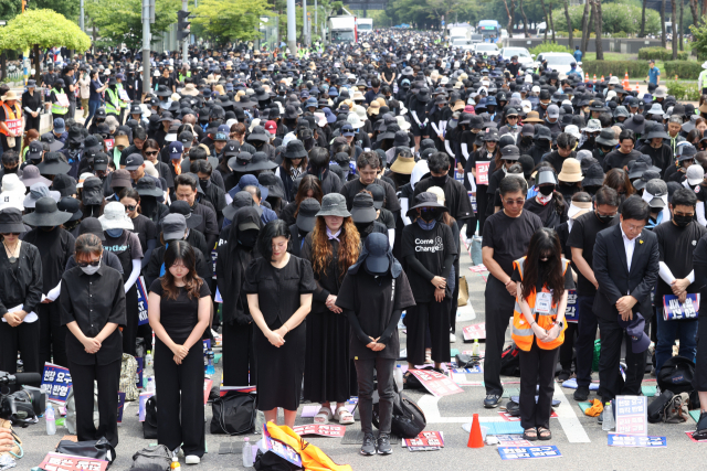 26일 오후 서울 영등포구 국회 앞에서 전국교사일동이 연 '국회 입법 촉구 추모집회'에서 참가자들이 묵념하고 있다. 이들은 지난 7월 22일부터 매 주말 공교육 정상화와 지난달 사망한 서초구 초등학교 교사 사건의 진상 규명을 위한 집회를 열고 있다. 연합뉴스