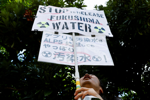 25일 일본 도쿄 총리 관저 앞에서 후쿠시마 제1원자력발전소 오염수 방류에 반대하는 시위대가 피켓을 들고 있다. /연합뉴스