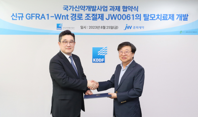 박찬희(왼쪽) JW그룹 CTO와 묵현상 국가신약개발사업단장이 지난 25일 서울 KPX빌딩에서Wnt 표적 탈모치료제 ‘JW0061’ 연구개발 협약식을 체결하고 기념 촬영을 하고 있다. 사진제공=JW중외제약