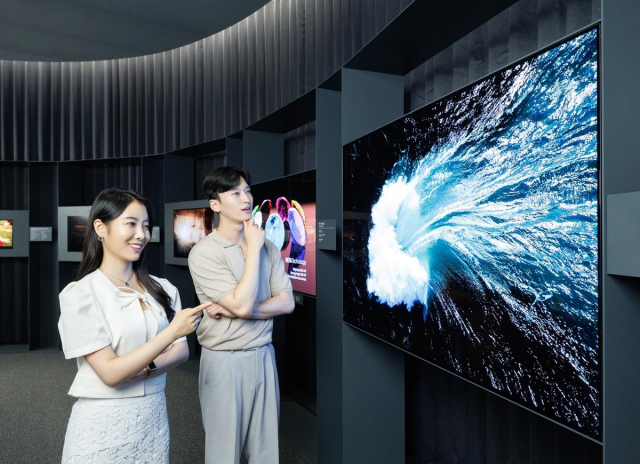 LG디스플레이 모델들이 ‘메타 테크놀로지’를 적용한 3세대 OLED TV 패널을 살펴보고 있다. 사진 제공=LG디스플레이