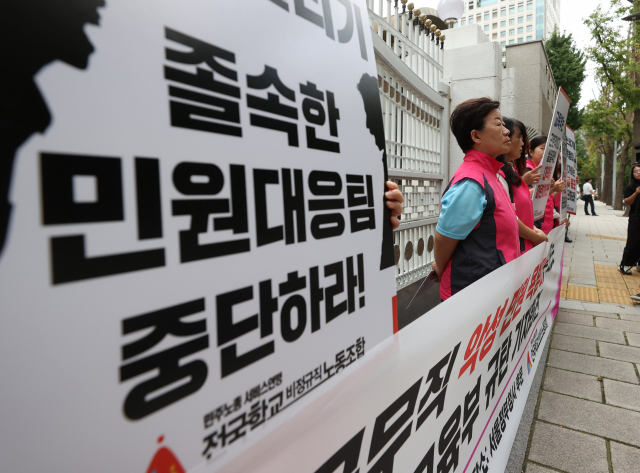 16일 오전 서울 종로구 정부서울청사 후문에서 민주노총 서비스연맹 전국학교비정규직노동조합이 연 ‘교육공무직 악성 민원 욕받이로 내모는 교육부 규탄 기자회견’에서 참가자들이 손팻말을 들고 있다. 연합뉴스