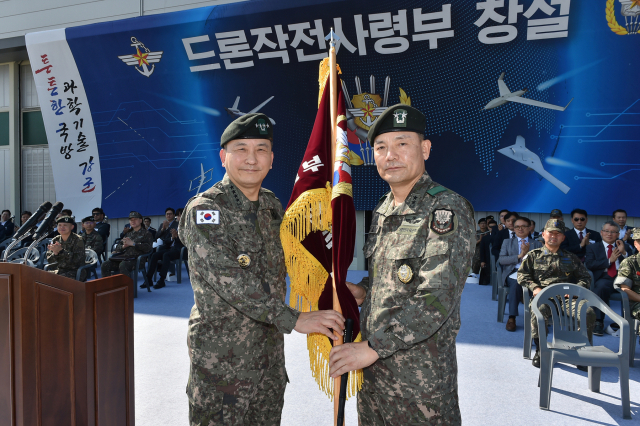 1일 개최된 드론작전사령부 창설식에서 김승겸 합참의장(왼쪽)이 초대 드론작전사령관 이보형 소장(오른쪽)에게 부대기를 수여하고 있다. 사진 제공=합참