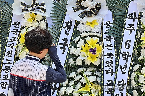 2일 오전 서울 양천구 소재 초등학교 앞에 마련된 숨진 교사 A씨의 추모공간에서 한 추모객이 눈물을 닦고 있다. 지난 1일 경찰과 서울시교육청에 따르면 지난달 31일 오후 7시께 고양시 덕양구의 한 아파트에서 14년차 교사 A(38)씨가 추락해 숨졌다. A씨는 서울 양천구의 S초등학교에서 6학년 담임을 맡았으며, 전날까지 질병 휴직 중이었다. 연합뉴스