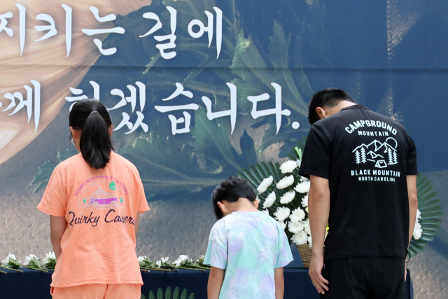 서울 서초구 서이초등학교에서 근무하다가 숨진 여교사의 49재를 맞은 4일 경북 포항시 북구 양덕동 경상북도교육청문화원에 마련된 추모공간에서 시민이 자녀와 함께 묵념하고 있다. 연합뉴스