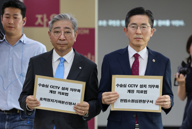 이필수 대한의사협회 회장(오른쪽)과 윤동섭 대한병원협회 회장이 5일 오전 서울 종로구 헌법재판소에 수술실 CCTV 설치 의무 법제화 헌법소원 청구서를 제출하기 위해 이동하고 있다. 연합뉴스