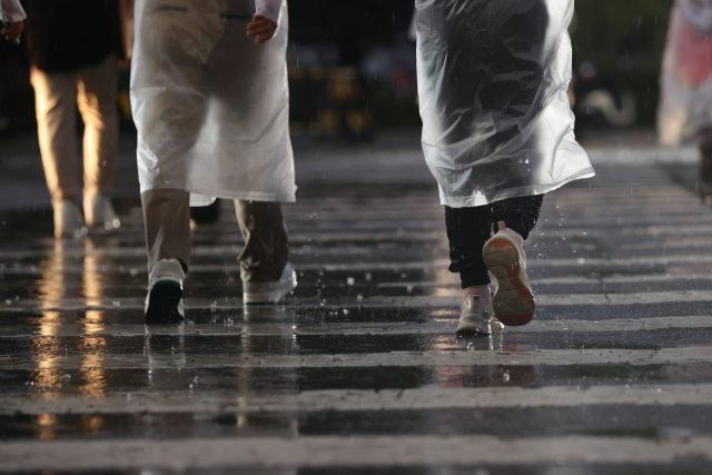 지난 5일 서울 잠실야구장 인근에서 시민들이 우산을 쓰고 걸어가고 있다. 연합뉴스
