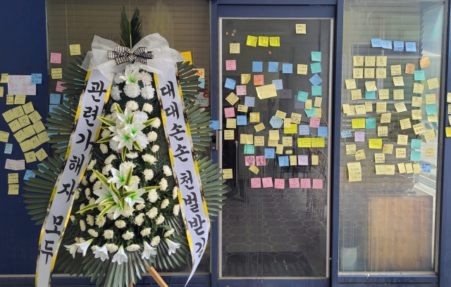 12일 오후 가해자로 지목된 학부모가 대전 유성구에서 운영 중인 가게 앞에 학부모를 비판하는 내용의 근조화환이 놓여있다. 연합뉴스