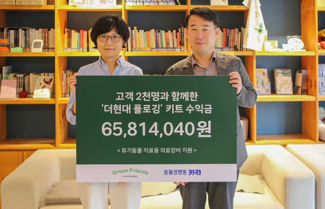 양명성(오른쪽) 현대백화점 영업전략담당 상무가 14일 서울 서교동 소재 ‘동물권행동 카라’ 사무실에서 전진경 대표와 ‘유기동물 치료 의료장비 지원 기금’을 전달한 뒤 기념 촬영을 하고 있다. 사진 제공=현대백화점