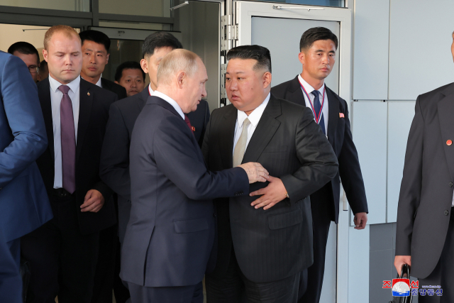 김정은(오른쪽) 북한 국무위원장과 블라디미르 푸틴 러시아 대통령이 13일 연회를 마치고 작별인사를 하고 있다. 연합뉴스