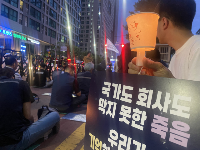 14일 신당역 스토킹 살인사건 추모행사가 열린 신당역 10번 출구 앞에서 행사 참석자가 피켓과 촛불을 들고있다. 이승령 기자