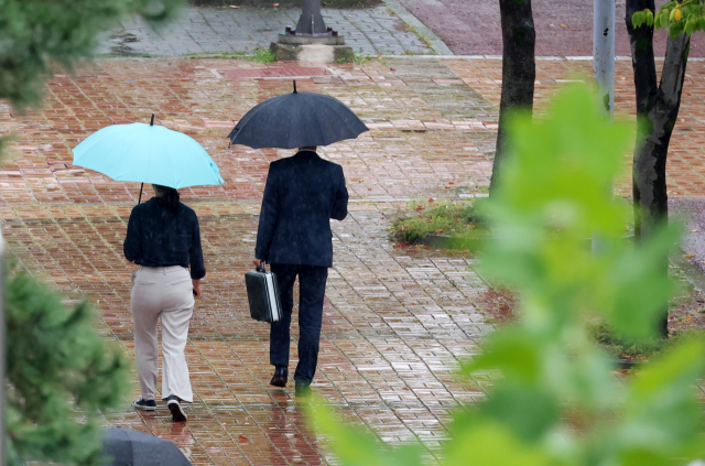 14일 오후 광주 서구 치평동에서 시민들이 내리는 가을비에 우산을 쓰고 걸어가고 있다.연합뉴스