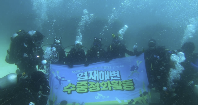 제주 협재해변 수중 정화활동에 나선 SK렌터카 사내 스킨스쿠버동호회 ‘윤슬.Sea’, 해양환경보호단체 ‘오션케어’, UDT 자원봉사단 ‘바다살리기 운동본부’, 이호어촌계 해녀 등이 기념사진을 촬영하고 있다. 사진 제공=SK렌터카