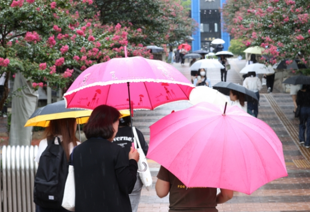 전국 대부분 지역에 비가 예보된 지난 13일 오후 서울 용산구 숙명여대 인근에서 시민들이 우산을 쓰고 걸어가고 있다. 연합뉴스