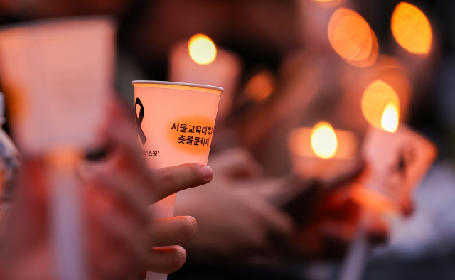 서울 서이초등학교 교사의 49재 추모일인 지난 9월 4일 오후 서울 서초구 서울교육대학교에서 열린 촛불문화제에서 참가자들이 촛불을 들고 있다. 연합뉴스