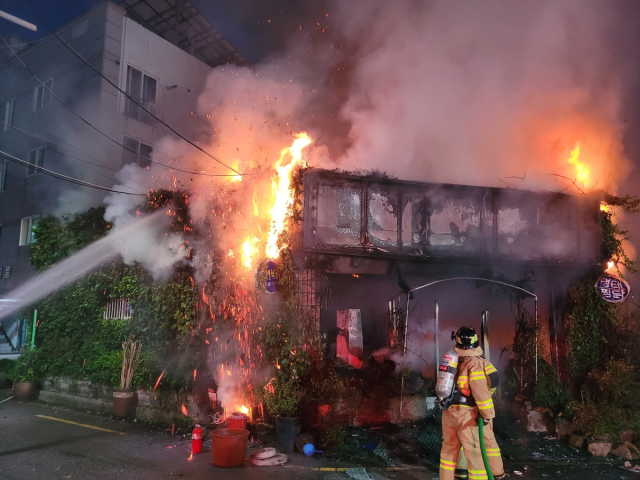 지난 18일 오후 경남 양산시 식당 화재 현장에서 한 소방대원이 불을 끄고 있다. 연합뉴스