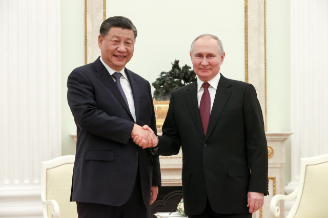 시진핑(왼쪽) 중국 국가주석과 블라디미르 푸틴 러시아 대통령이 3월 20일(현지 시간) 러시아 수도 모스크바의 크렘린궁에서 비공식 회담을 하기에 앞서 악수를 하고 있다. 로이터연합