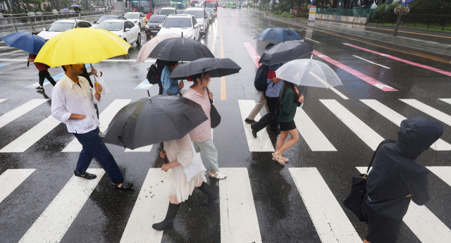 비가 내린 20일 오후 우산을 쓴 시민들이 서울 종로구 광화문네거리에서 길을 건너고 있다. 연합뉴스